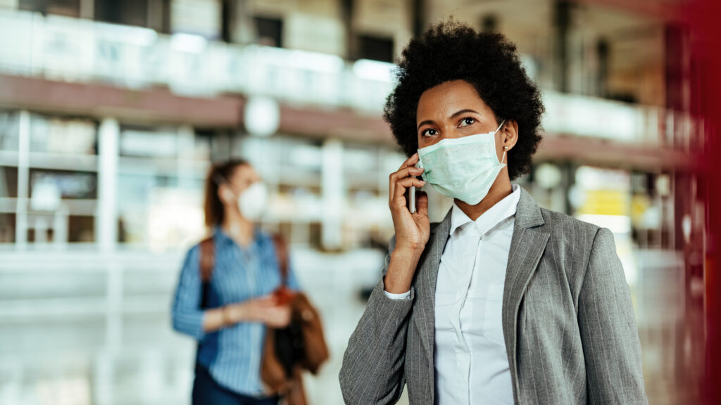 African American businesswoman wearing protective mask while mak