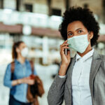 African American businesswoman wearing protective mask while mak