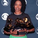 Lauryn Hill holding her five Grammy awards during the 1998 Grammy Awards.