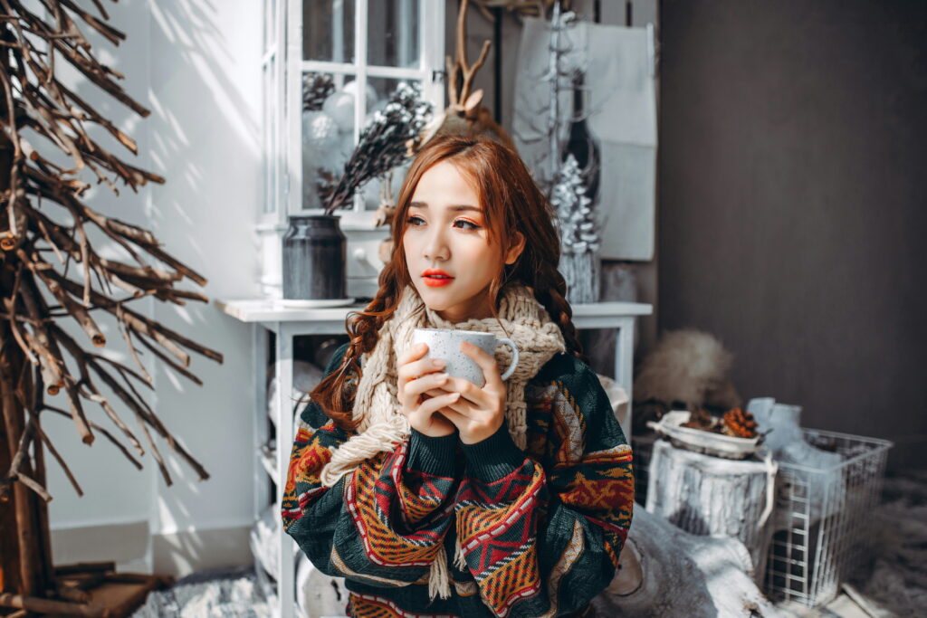 Woman holding a mug and looking into the distance as part of a story on spending the holidays without a loved one. (Credit: Anthony Tran via Unsplash)