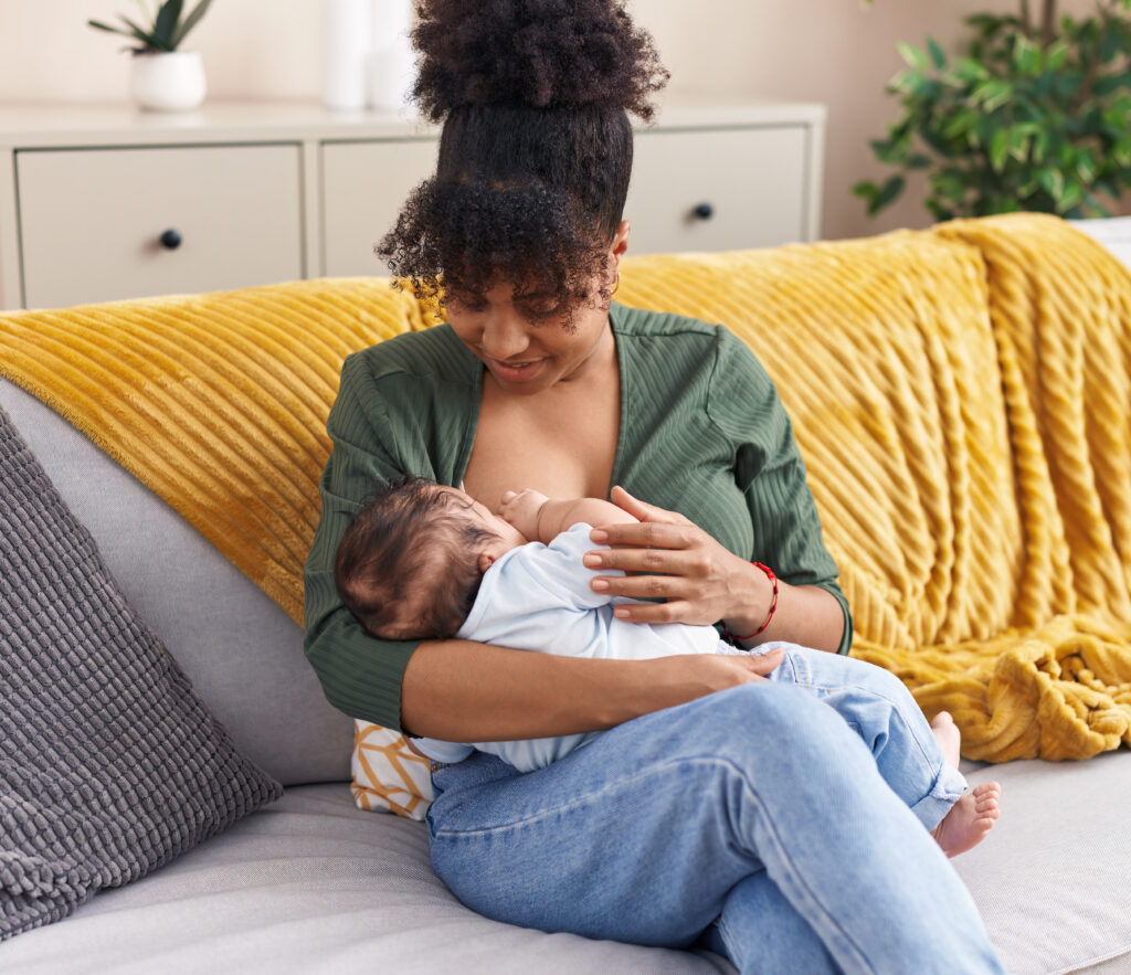 Mother and son sitting on sofa breastfeeding at home as part of a story on breastfeeding tips for new moms. (Credit: Krakenimages.com via Adobe Stock)