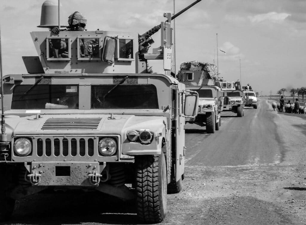 An image depicting military trucks for a story on how "war" in American media normalizes atrocity. (Credit: Mike Cook / Pixabay)
